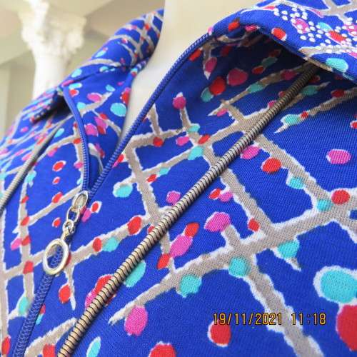 New blue patternened slip over stretch polyester top. Short front zip and embellished collar.Size 36