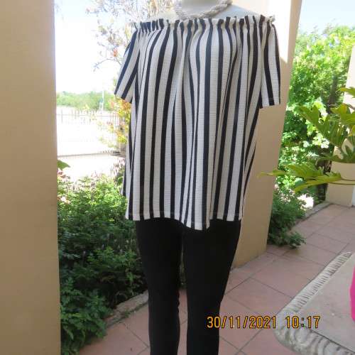Get bonus fashion points in this black/white vertical striped off shoulder top.Size 44/46 by EDITION