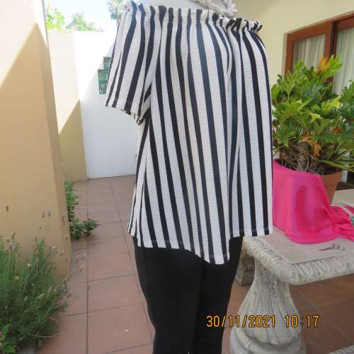 Get bonus fashion points in this black/white vertical striped off shoulder top.Size 44/46 by EDITION