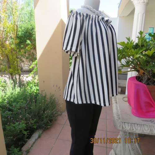 Get bonus fashion points in this black/white vertical striped off shoulder top.Size 44/46 by EDITION
