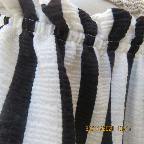 Get bonus fashion points in this black/white vertical striped off shoulder top.Size 44/46 by EDITION