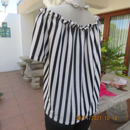 Get bonus fashion points in this black/white vertical striped off shoulder top.Size 44/46 by EDITION