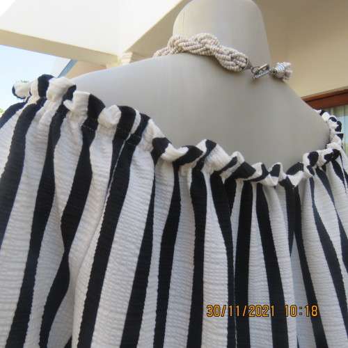 Get bonus fashion points in this black/white vertical striped off shoulder top.Size 44/46 by EDITION