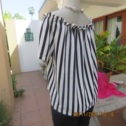 Get bonus fashion points in this black/white vertical striped off shoulder top.Size 44/46 by EDITION