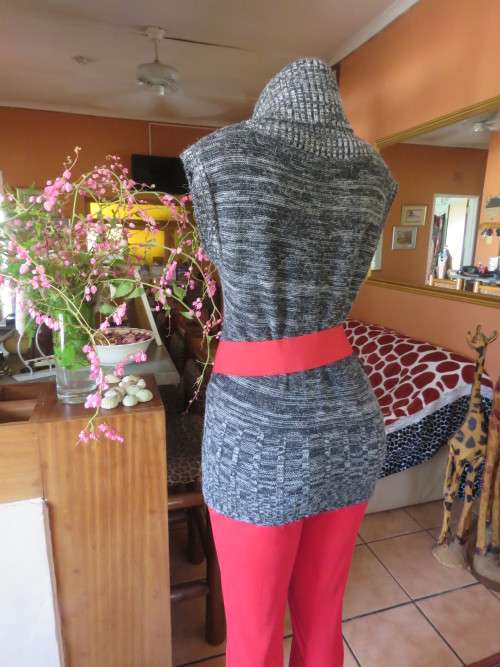 Stylish black/white mottled long acrylic knit sleeveless top.Foldover fireside collar.Size 36/12.