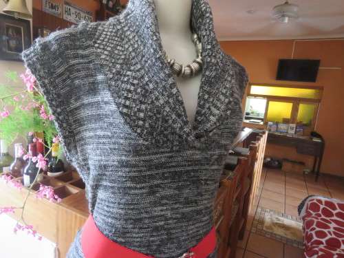 Stylish black/white mottled long acrylic knit sleeveless top.Foldover fireside collar.Size 36/12.