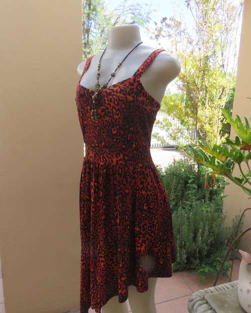Get noticed in this brick and black high/low animal print poly stretch dress.By WWW size 36.