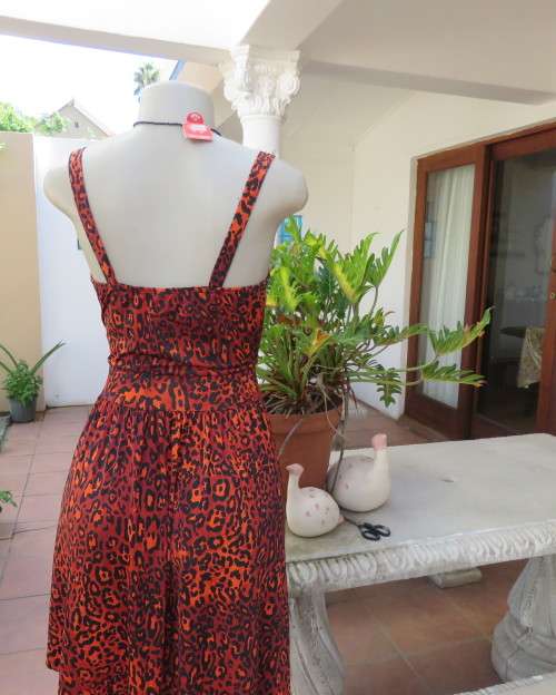 Get noticed in this brick and black high/low animal print poly stretch dress.By WWW size 36.