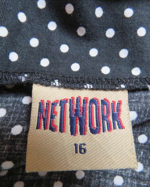 Easy to wear black A-Line calf length skirt with white polkadots.Yoke style waistband.Size 40/16.