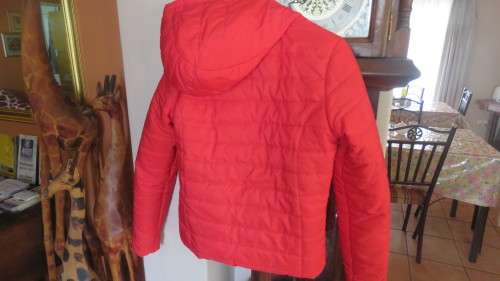 As new red padded long sleeve hooded jacket size 30/6 by RT. Kangaroo pockets.100% polyester.