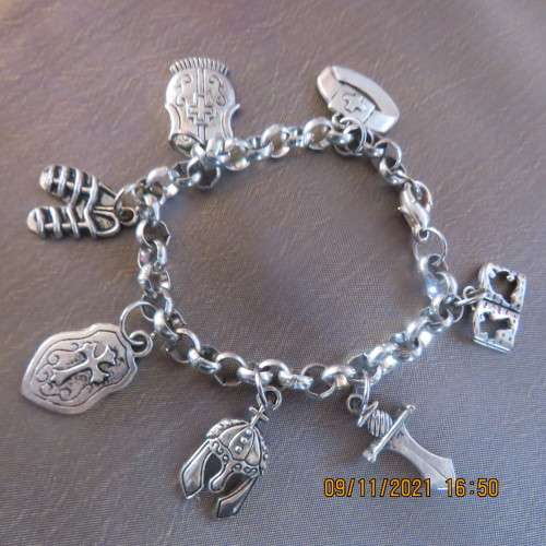 Beautiful bracelet with 7 charms on stainless steel chain. Length 18cm. New condition.