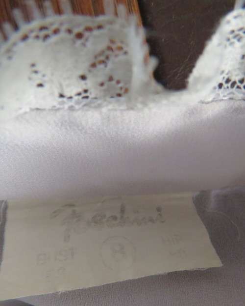 Stylish 80`s long sleeve button down light grey blouse with high banded collar.Size 32 by FOSHINI.