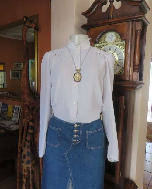 Stylish 80`s long sleeve button down light grey blouse with high banded collar.Size 32 by FOSHINI.