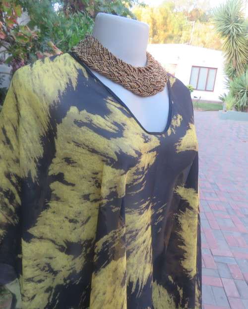 Stunning throw over top in black and mustard sheer polyester. Neckline edged with black satin.As new