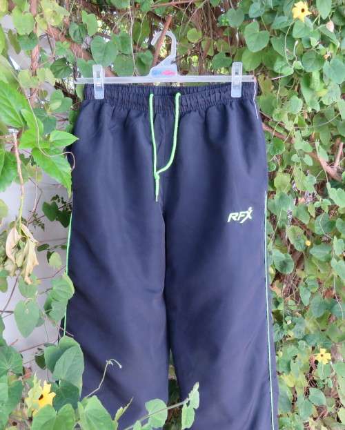 Men`s navy polyester tracksuit pants with green edging size Medium by REFLEX.Zips on leg seams.