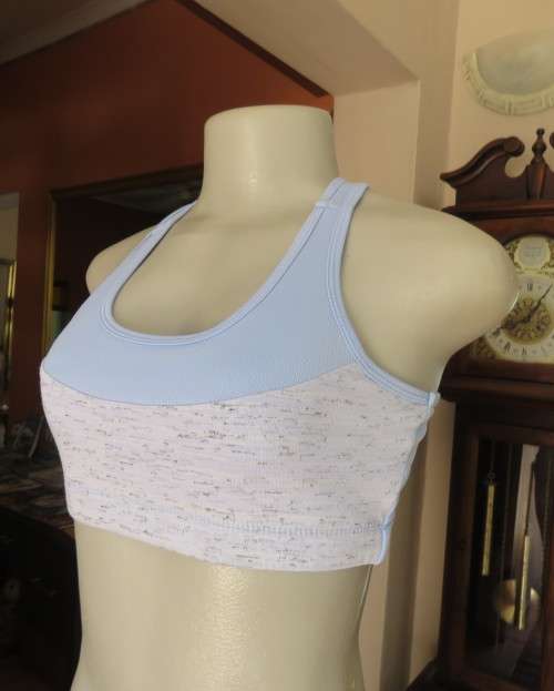 As new light blue size 32 sports bra by MAXED in stretch polyester.