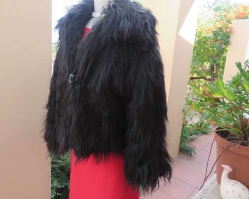 Black faux fur hip length jacket with open rounded collar.Close with long button and loop.Size 38/40