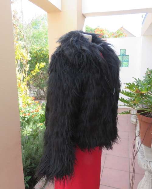 Black faux fur hip length jacket with open rounded collar.Close with long button and loop.Size 38/40