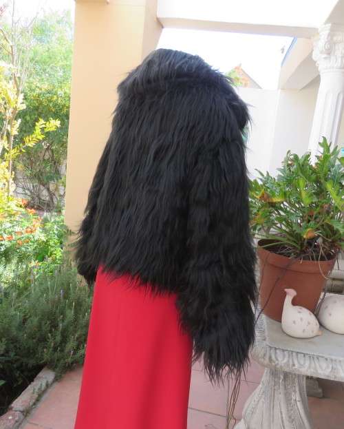 Black faux fur hip length jacket with open rounded collar.Close with long button and loop.Size 38/40