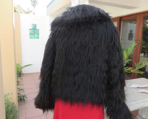 Black faux fur hip length jacket with open rounded collar.Close with long button and loop.Size 38/40