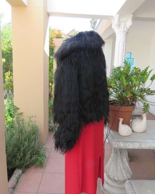 Black faux fur hip length jacket with open rounded collar.Close with long button and loop.Size 38/40