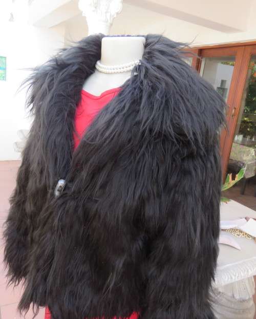 Black faux fur hip length jacket with open rounded collar.Close with long button and loop.Size 38/40