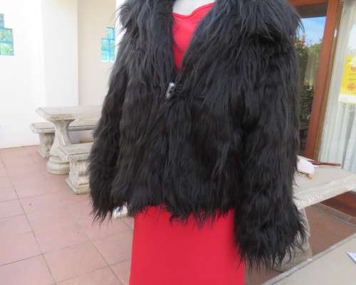 Black faux fur hip length jacket with open rounded collar.Close with long button and loop.Size 38/40