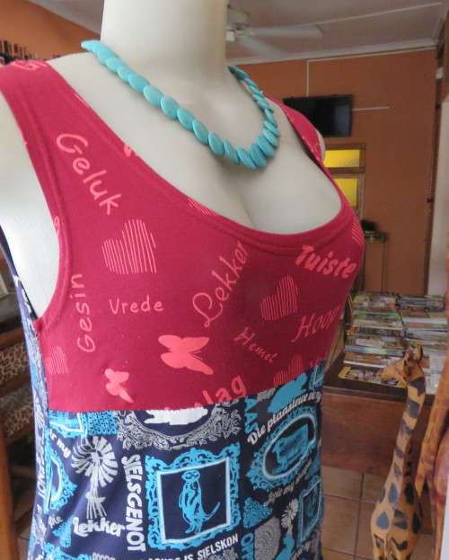 Delightful long navy top with maroon bust area. With Afrikaans logos and pictures.Size 34.As new