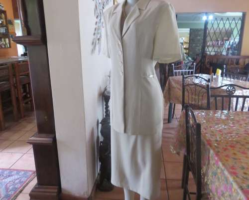 Stunning cream 2 pc skirt suite. Long tailored jacket/ankle length bandless skirt.Size 36.New cond.