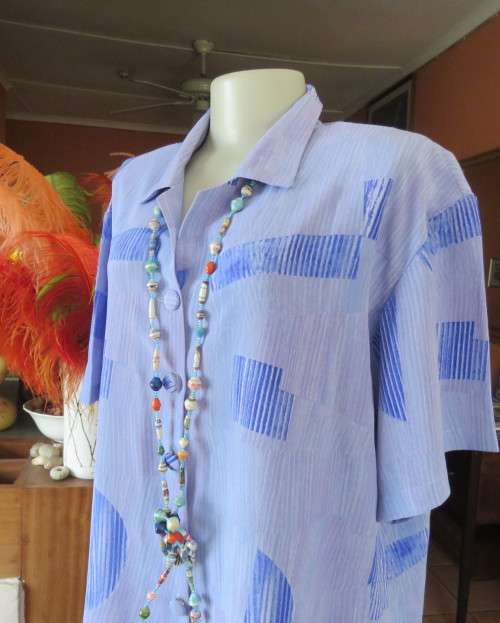 Smart light blue with darker blue graphic designs.Button down with open collar.Owner made size 44/20