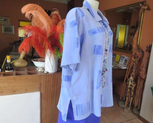 Smart light blue with darker blue graphic designs.Button down with open collar.Owner made size 44/20