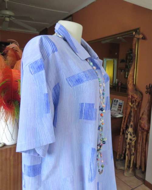Smart light blue with darker blue graphic designs.Button down with open collar.Owner made size 44/20