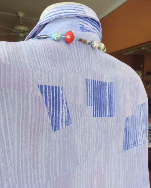 Smart light blue with darker blue graphic designs.Button down with open collar.Owner made size 44/20