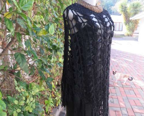 Black crochet lace stitch poncho in double knit acrylic yarn. Fringed. By KELSO.Best fit 32 to 36.