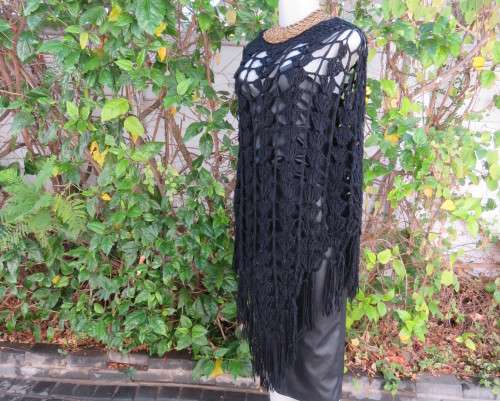 Black crochet lace stitch poncho in double knit acrylic yarn. Fringed. By KELSO.Best fit 32 to 36.
