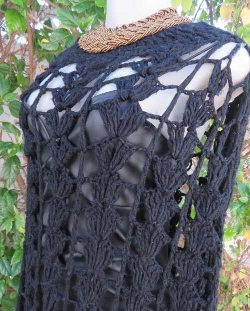 Black crochet lace stitch poncho in double knit acrylic yarn. Fringed. By KELSO.Best fit 32 to 36.