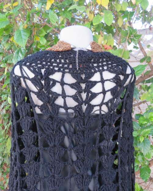 Black crochet lace stitch poncho in double knit acrylic yarn. Fringed. By KELSO.Best fit 32 to 36.