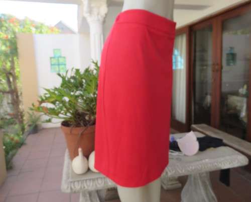 Smart red pencil skirt in red jersey fabric with some stretch.Size 42/18. Pleat at back. As new.