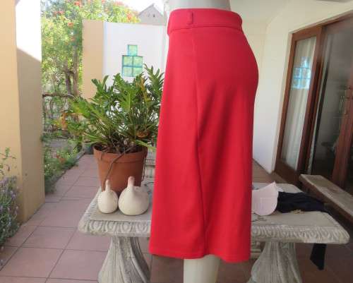 Smart red pencil skirt in red jersey fabric with some stretch.Size 42/18. Pleat at back. As new.