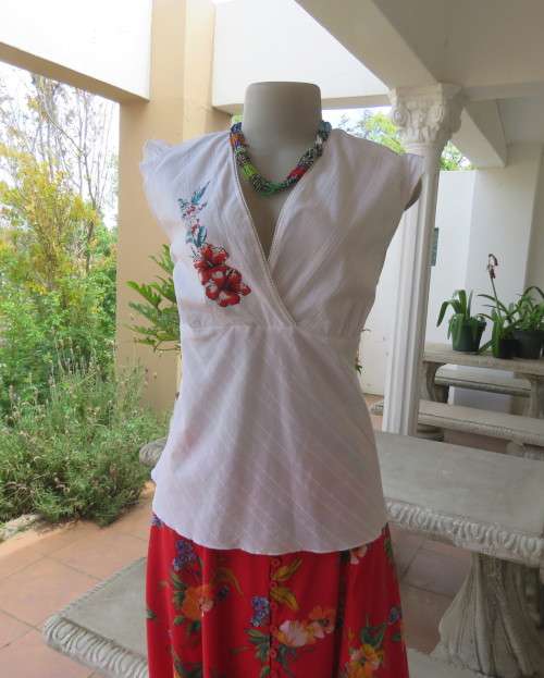 Sleeveless white 100%cotton embossed empire top.Crossover bust.Floral print decoration.42