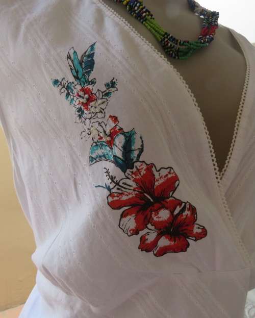 Sleeveless white 100%cotton embossed empire top.Crossover bust.Floral print decoration.42