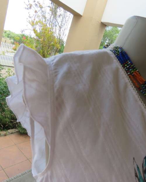 Sleeveless white 100%cotton embossed empire top.Crossover bust.Floral print decoration.42