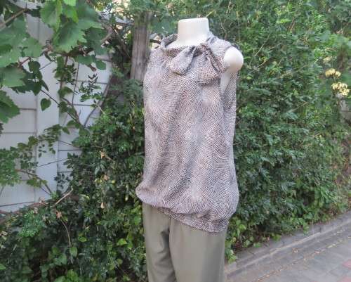 Chic brown/white animal print sleeveless slip over polyester top. Wide banded collar to tie. Size 38