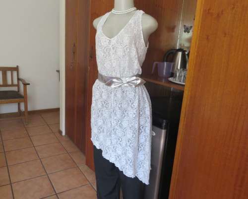 Pretty white/silver floral stretch acrylic lace asymmetrical top size 40/16.V neckline.As new.