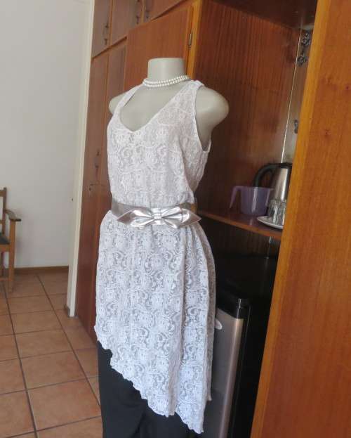 Pretty white/silver floral stretch acrylic lace asymmetrical top size 40/16.V neckline.As new.