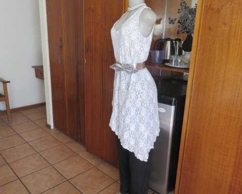 Pretty white/silver floral stretch acrylic lace asymmetrical top size 40/16.V neckline.As new.