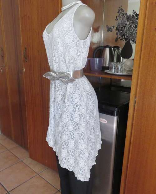 Pretty white/silver floral stretch acrylic lace asymmetrical top size 40/16.V neckline.As new.