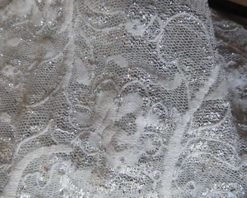 Pretty white/silver floral stretch acrylic lace asymmetrical top size 40/16.V neckline.As new.