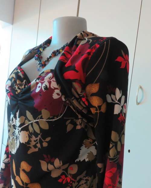 Black stretch polyester background with red,purple and gold floral pattern top.Tiny bolero.Size 38