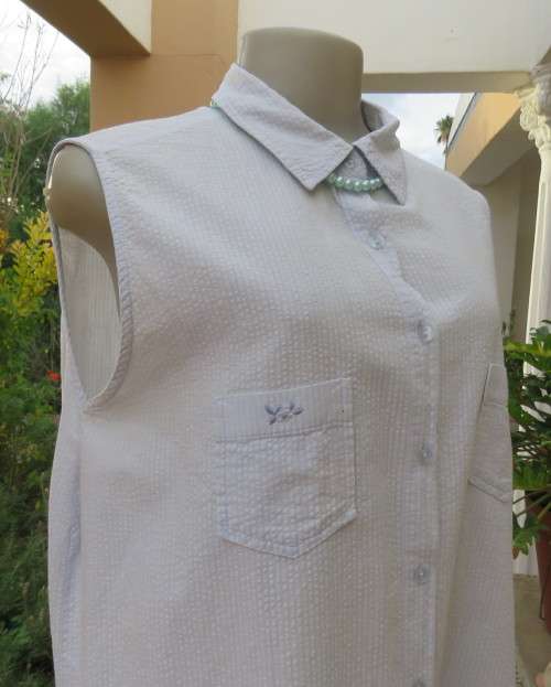 Cool pale blue sleeveless bubble cotton top with button down front.Size 40 to 42.Two cute pockets.